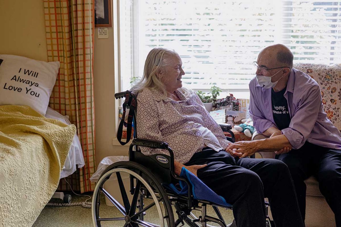 Jim Mangi, 73, reaches out to his wife Kathleen Schmidt’s, 72, at Brecon Village Memory Support Center in Saline. 