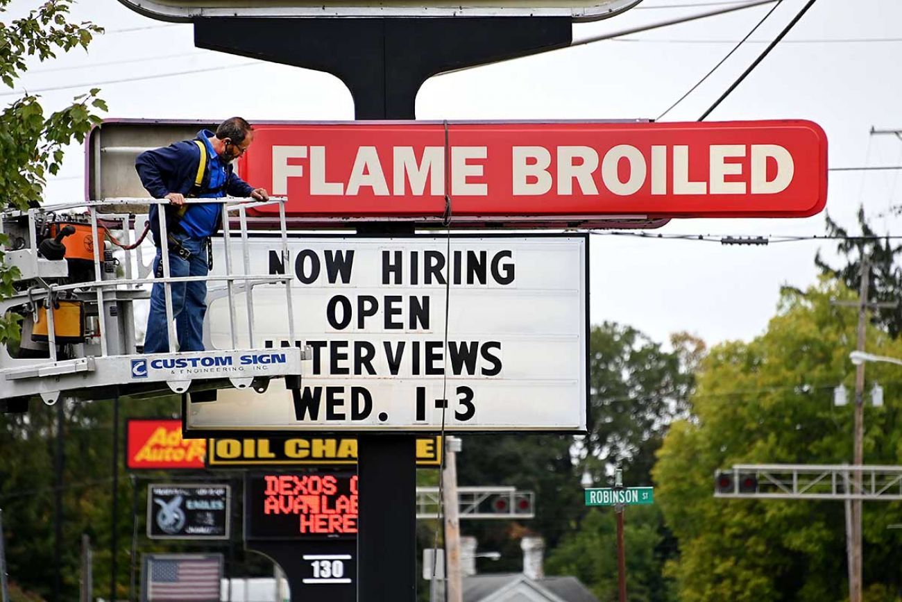 worker changing burger king sign