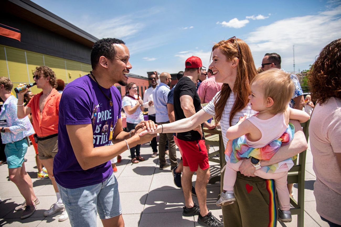 Mallory McMorrow holding a baby shaking a man's hand