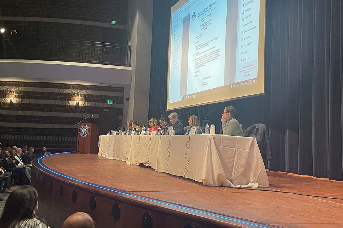 people sitting at a table on a stage