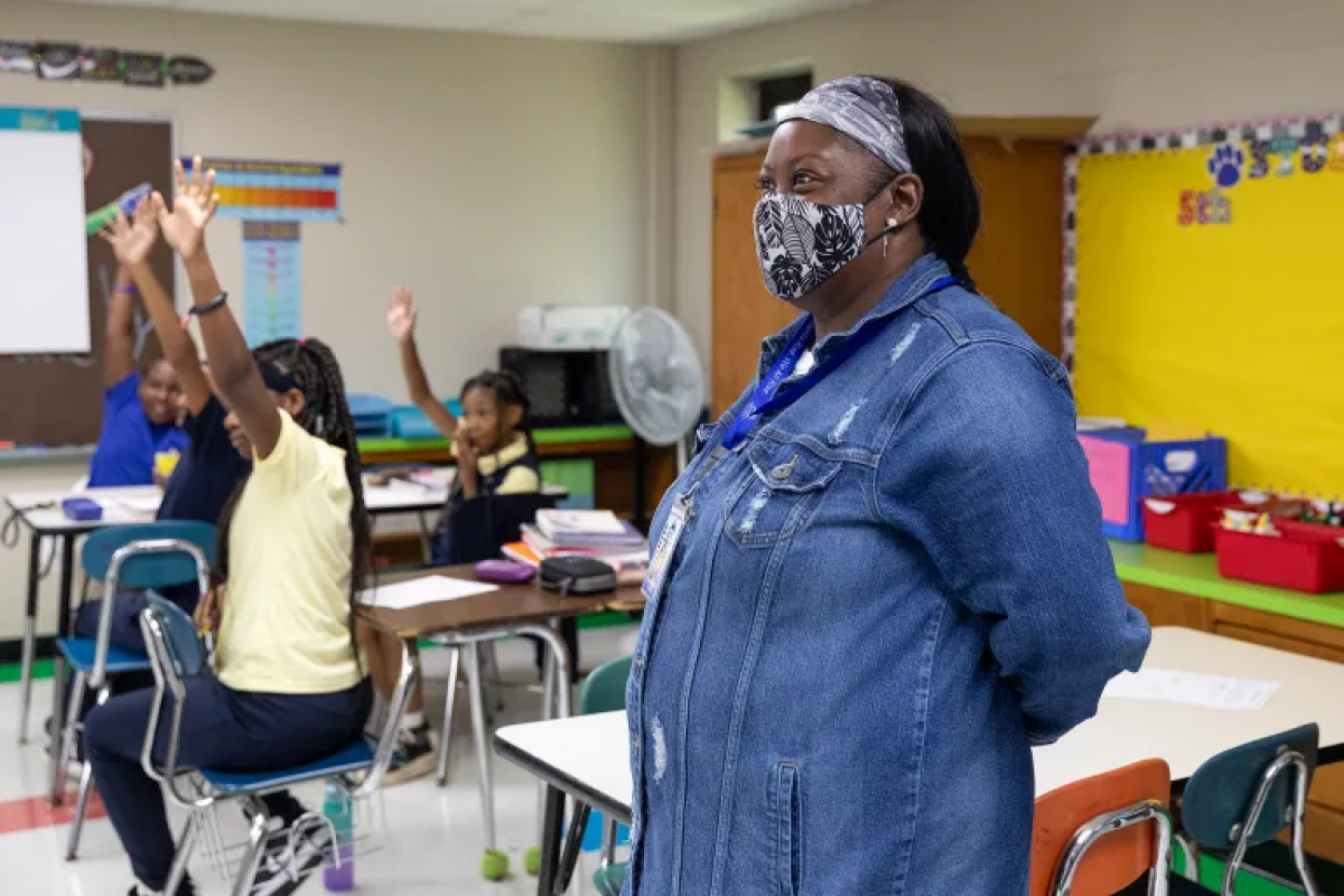 Teacher stands in classroom