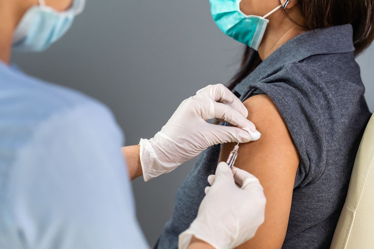 close up doctor holding syringe and using cotton before make injection to patient in medical mask.