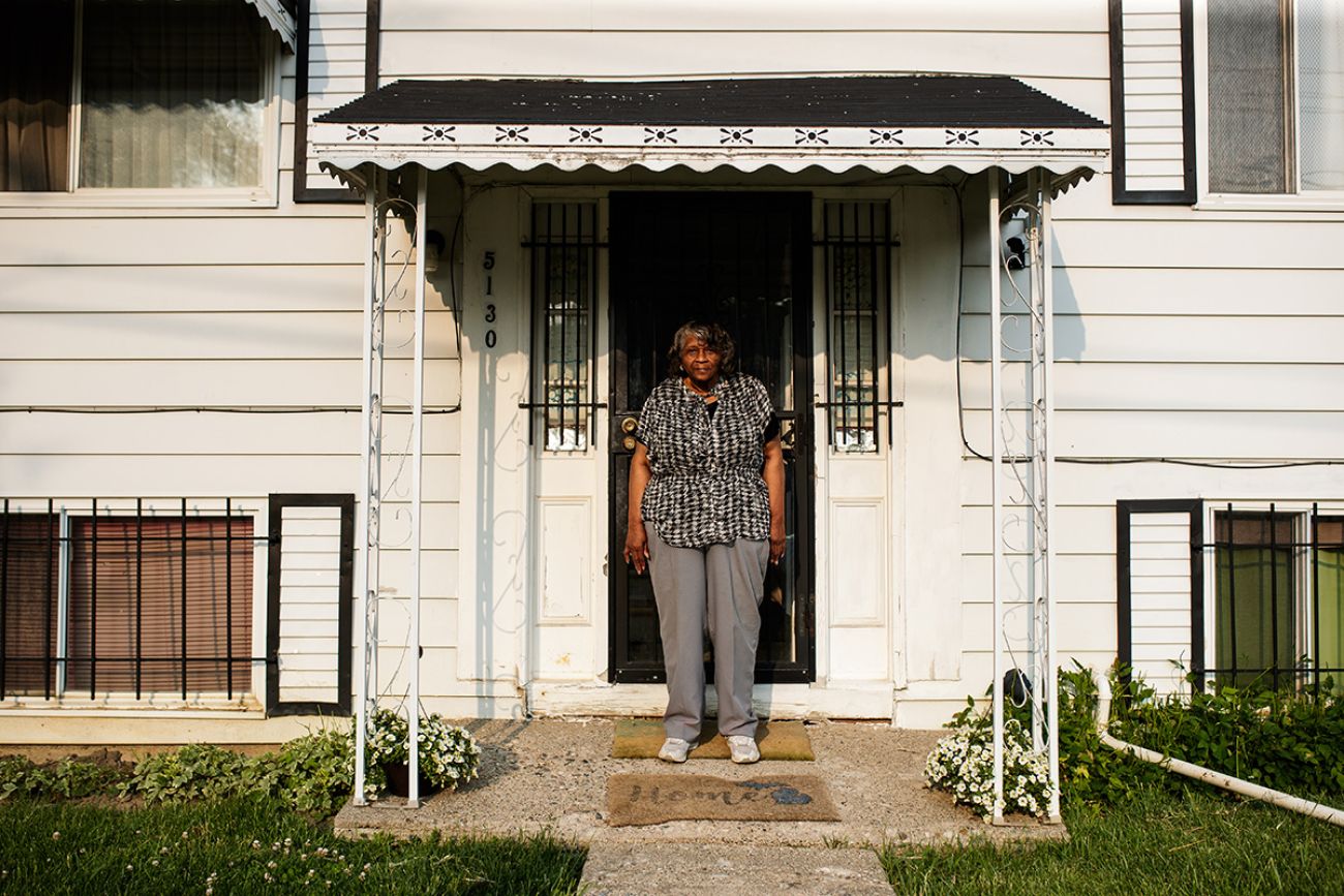 woman standing outside of white house