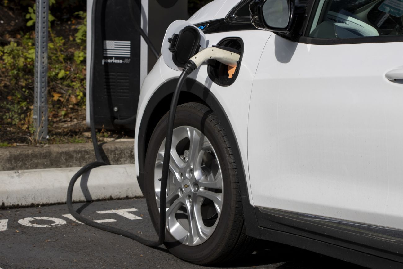 A Chevy Bolt EV electric car is seen charging at a public charging station in a parking lo