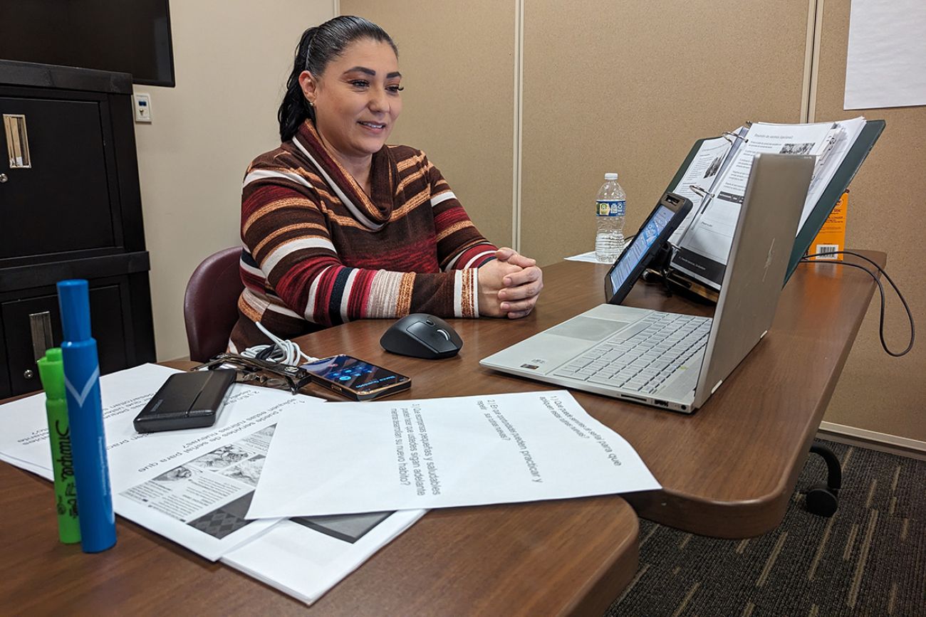 Teresa Plascencia sitting at a desk, looking at a laptop