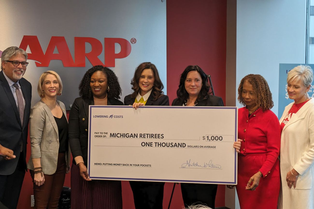 Gov. Gretchen Whitmer holding check