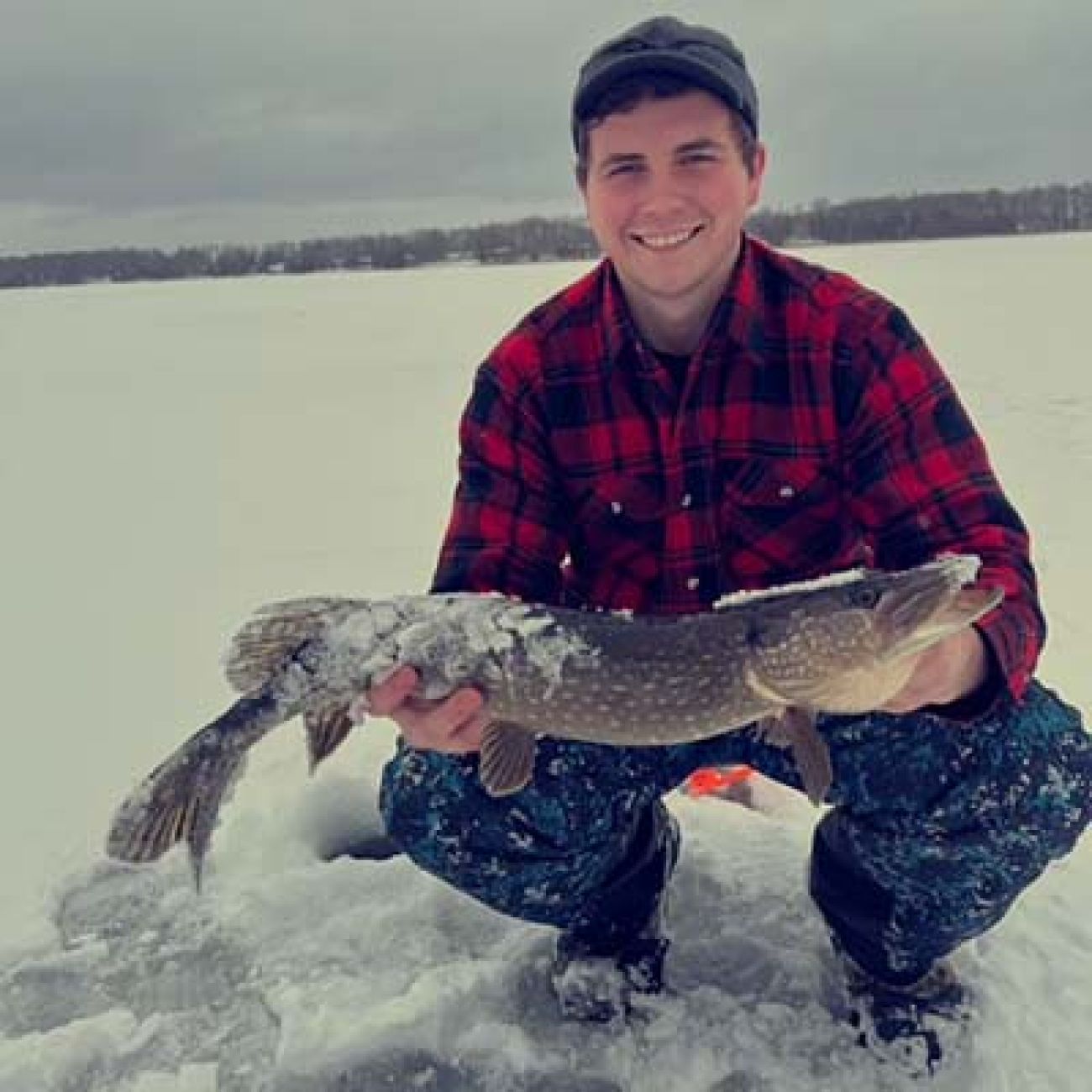 man poses with a fish