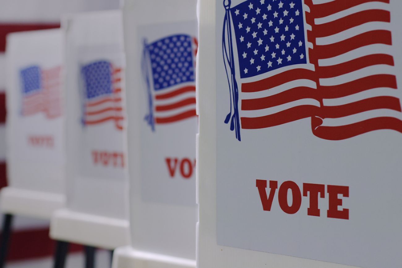 Voting booths line with US flag on the sides.