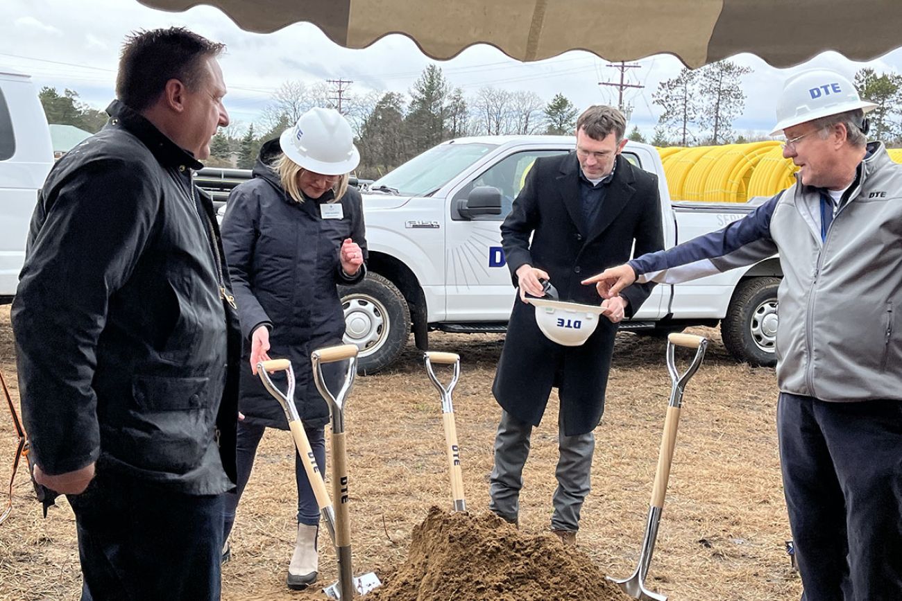 people standing in a circle with shovels 