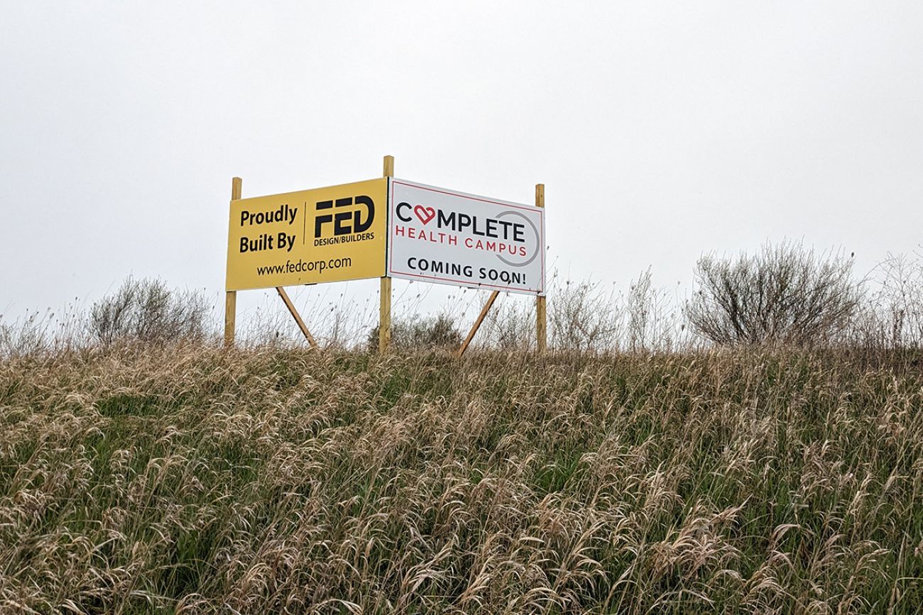 sign for the clare campus project. it's a yellow and white sign next to each other