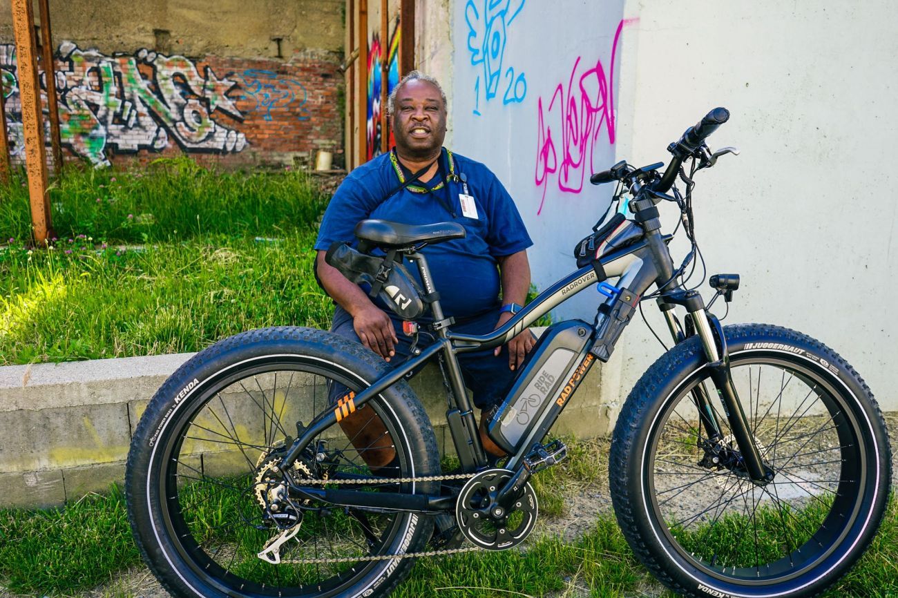 A man sitting next to his e-bike 