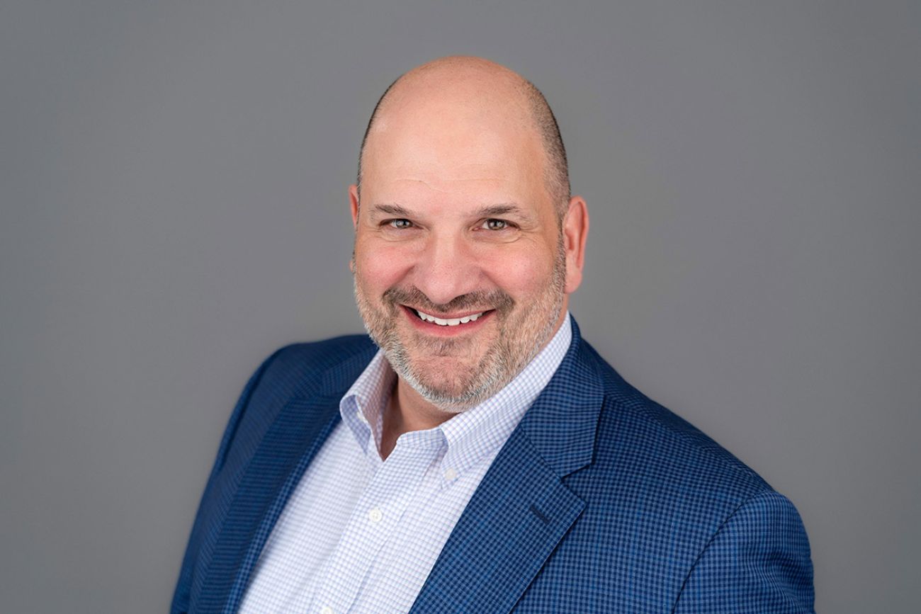 Carlo F. Cavallaro headshot. He is wearing a blue shirt and blue jacket