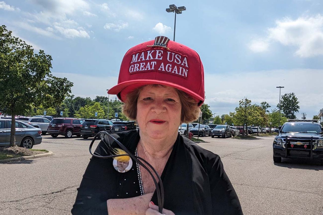 Mary Hamilton wears big red hat that says "Make USA Great Again"