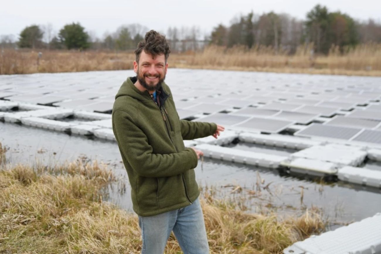 Man stands in front of solar installations.