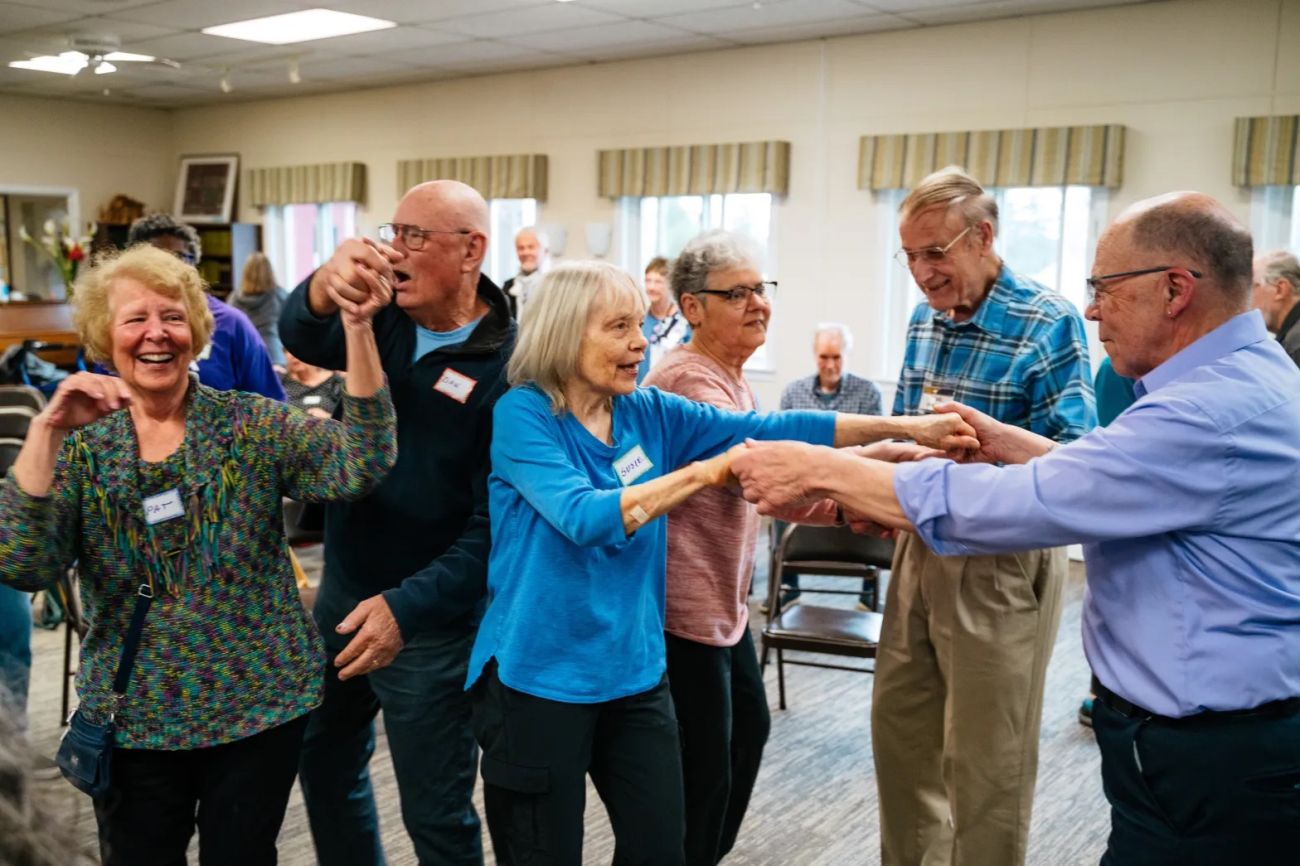 Elderly people dancing in a room