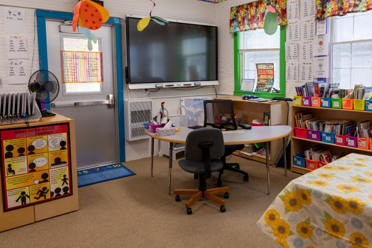 Inside Bois Blanc Pines School District. You can see a book shelfs and a teacher's desk