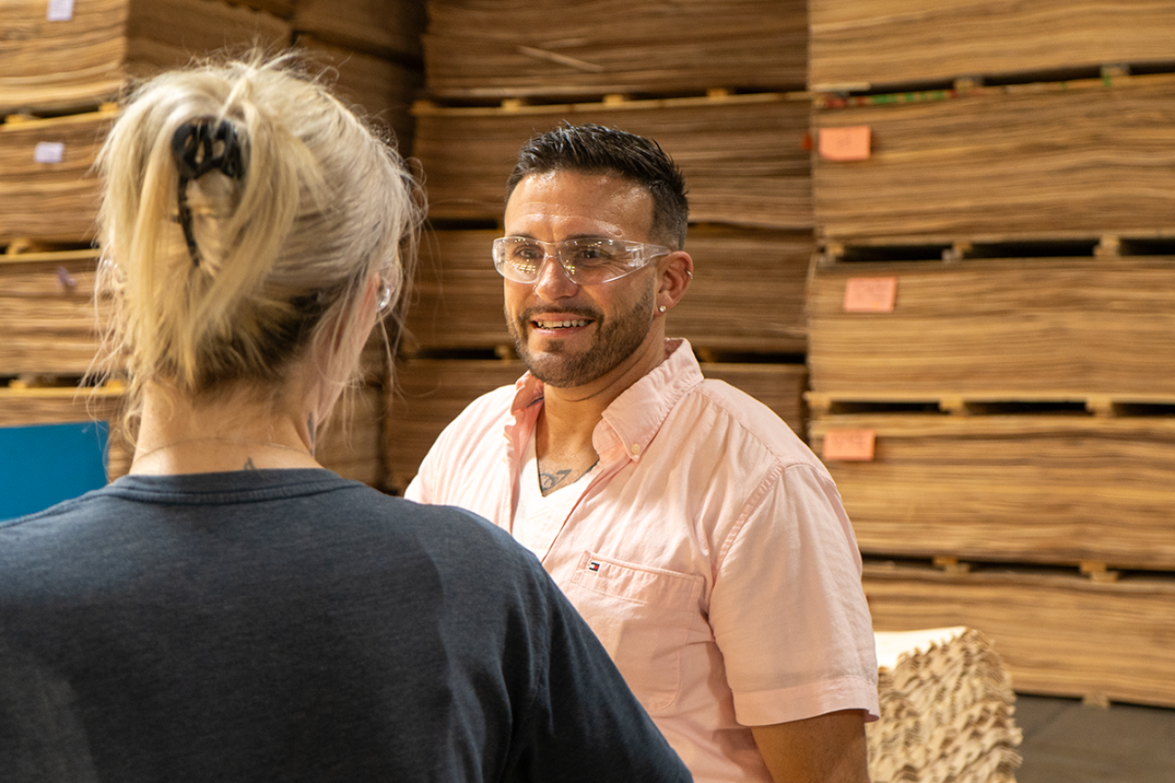 RJ Jones talking to Jolene Fassett in a room full of piles of plywood