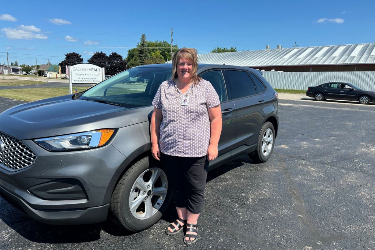 Tracy Antkoviak standing next to a car