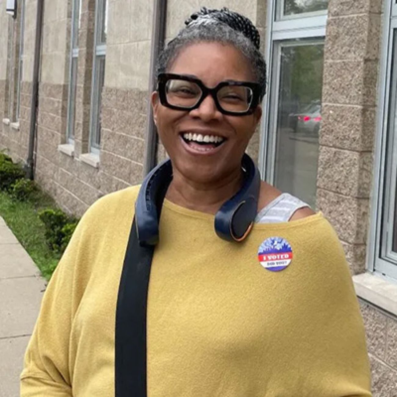 Stephanie Bond, wear a yellow sweater, poses for a picture outside