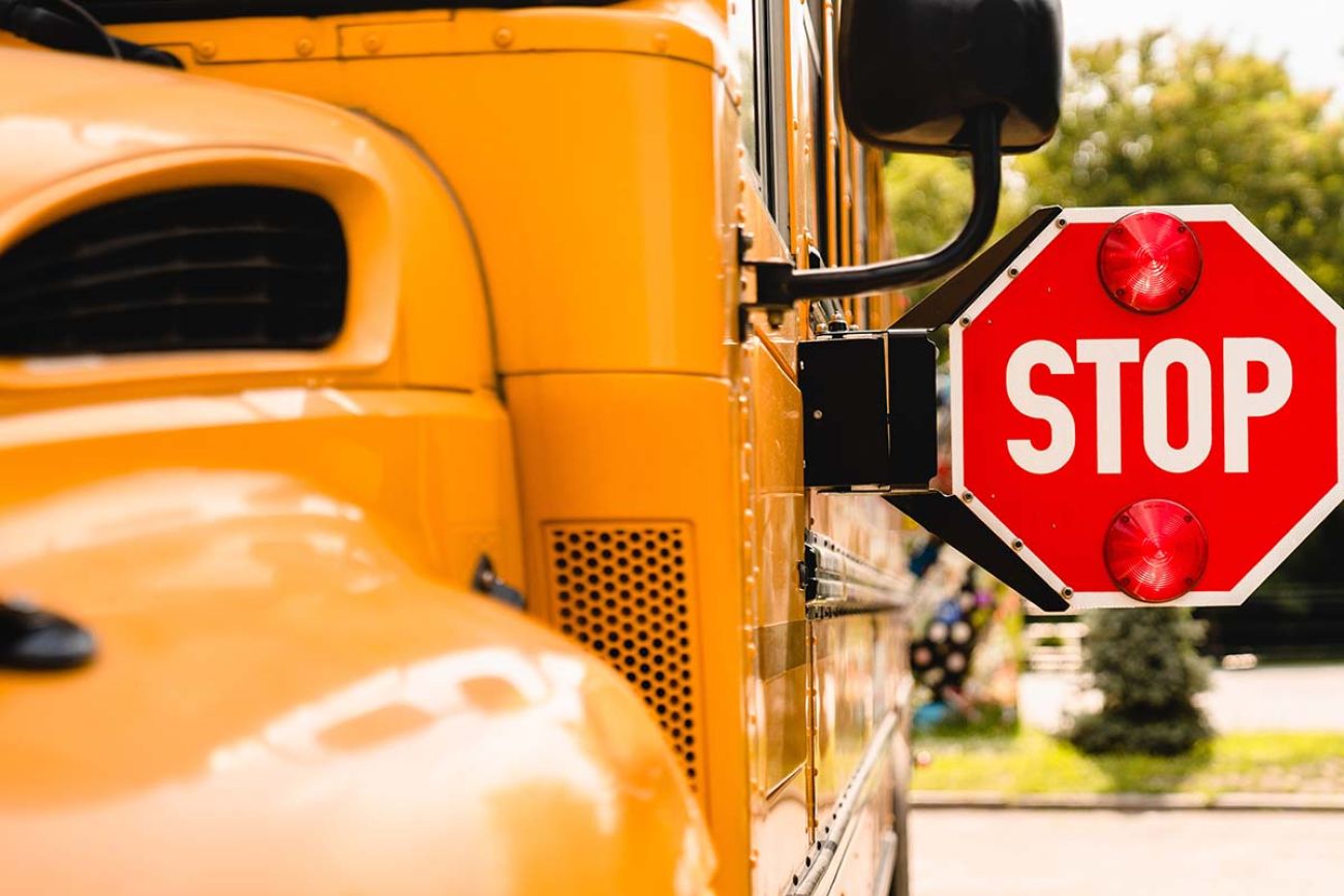 Stop sign on the side of a yellow school bus