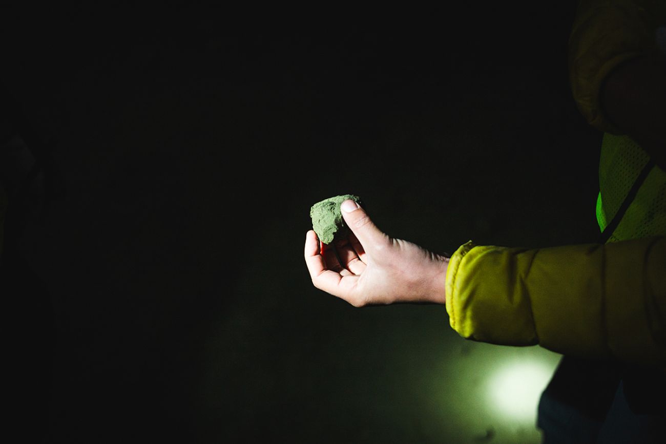 Someone holding copper concentrate. It looks like a rock