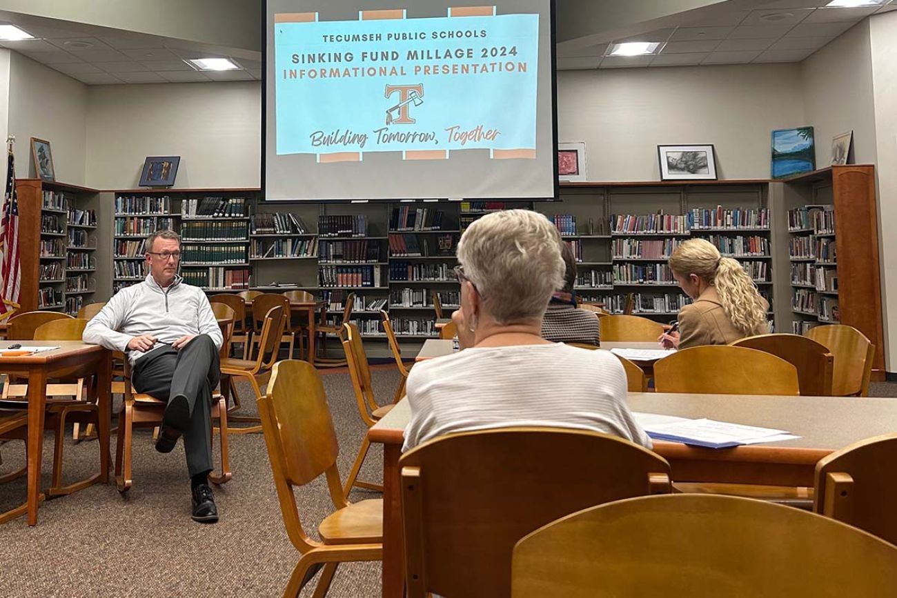 Tecumseh Public Schools Superintendent Matt Hilton sits at a chair while talking to others also sitting