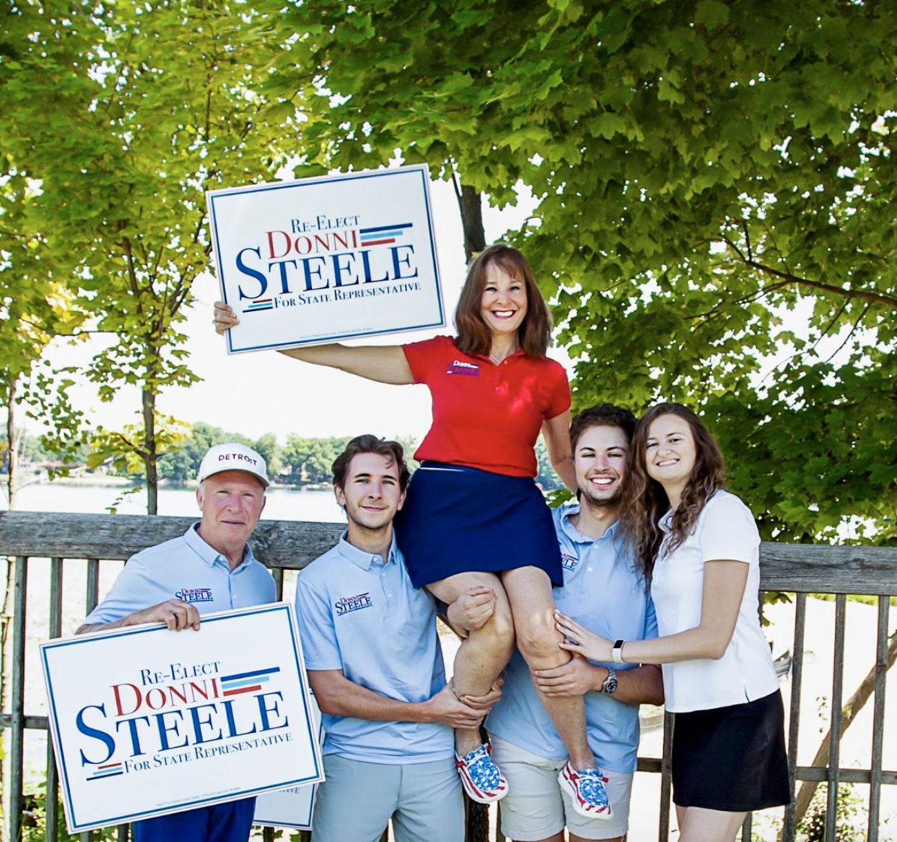 Rep. Donni Steele being held on her family's shoulders. They are holding signs to re-elect Steele