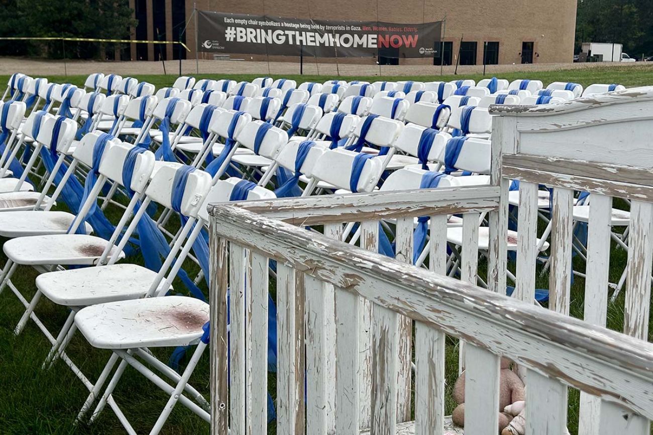 Rows of empty chairs. The chairs have blue ribbons 