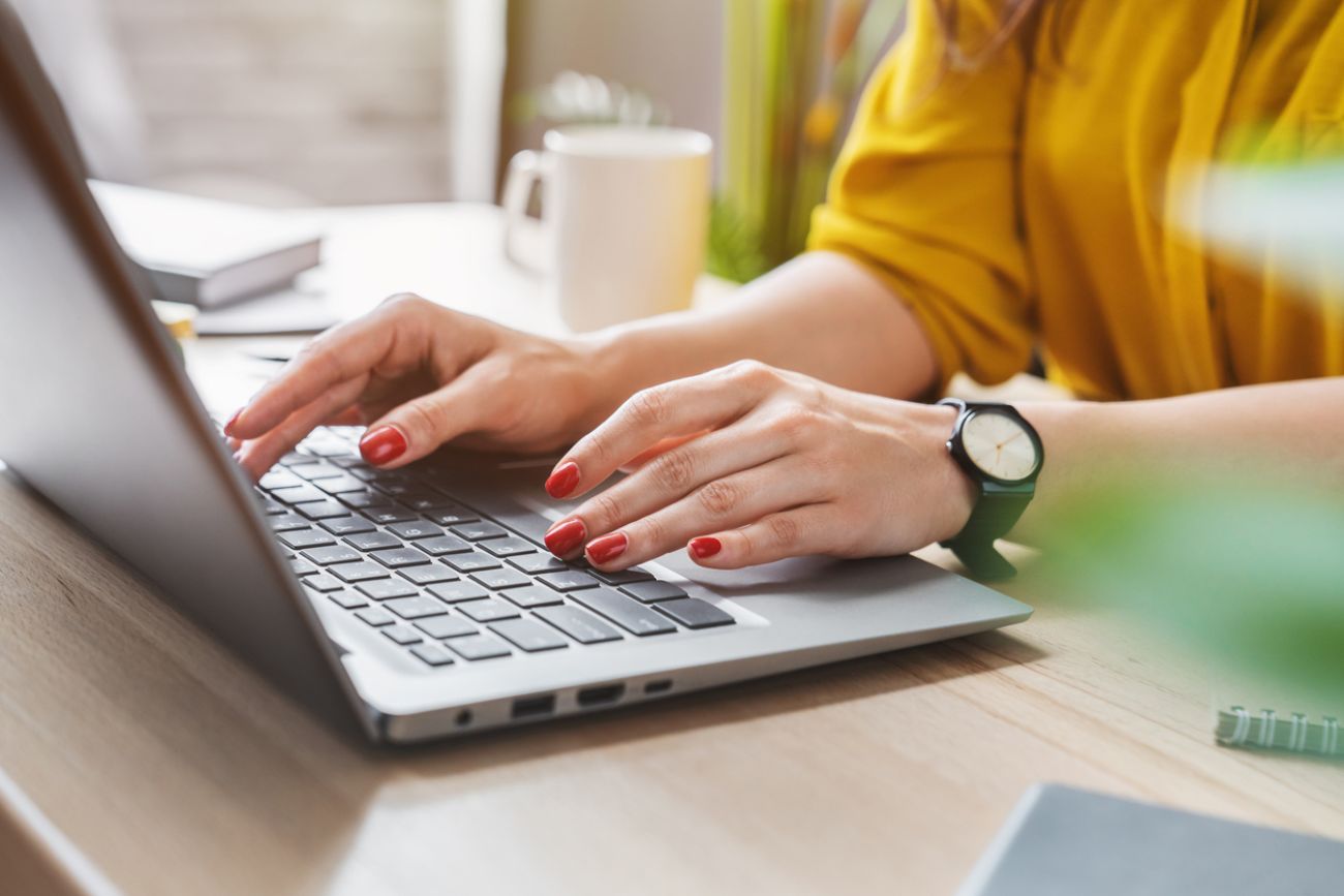 Cropped image of business woman hand working laptop computer in home office