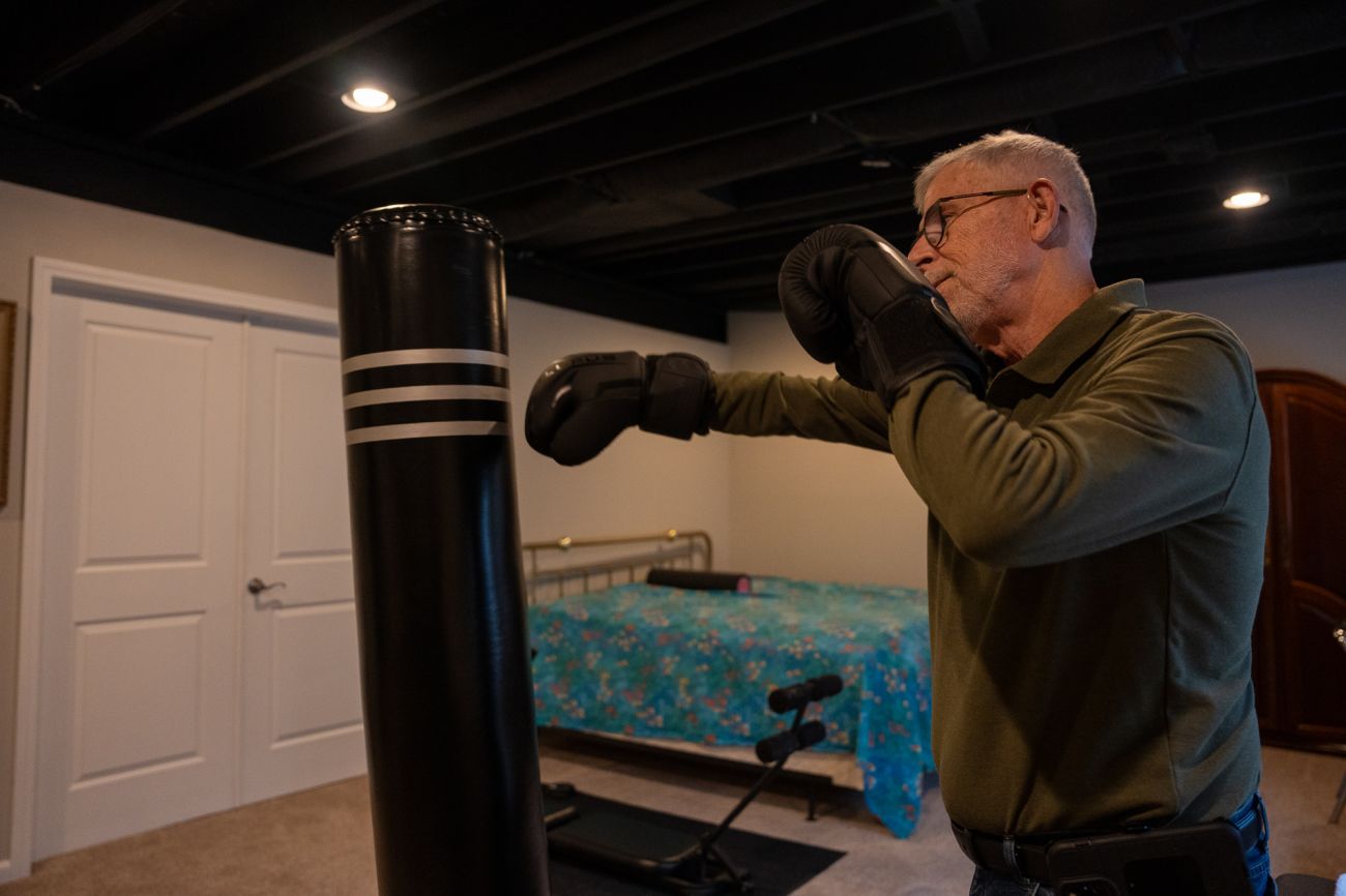 Dr. Arnold Beresh hitting a black kickboxing bag 