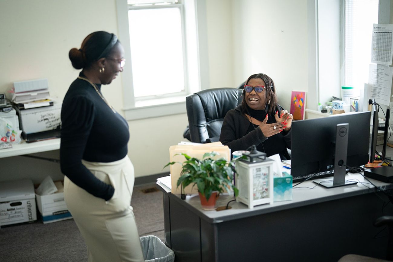 President and CEO Whitney Wardell and Housing Manager Sanita Virgil, speak into each other in the office