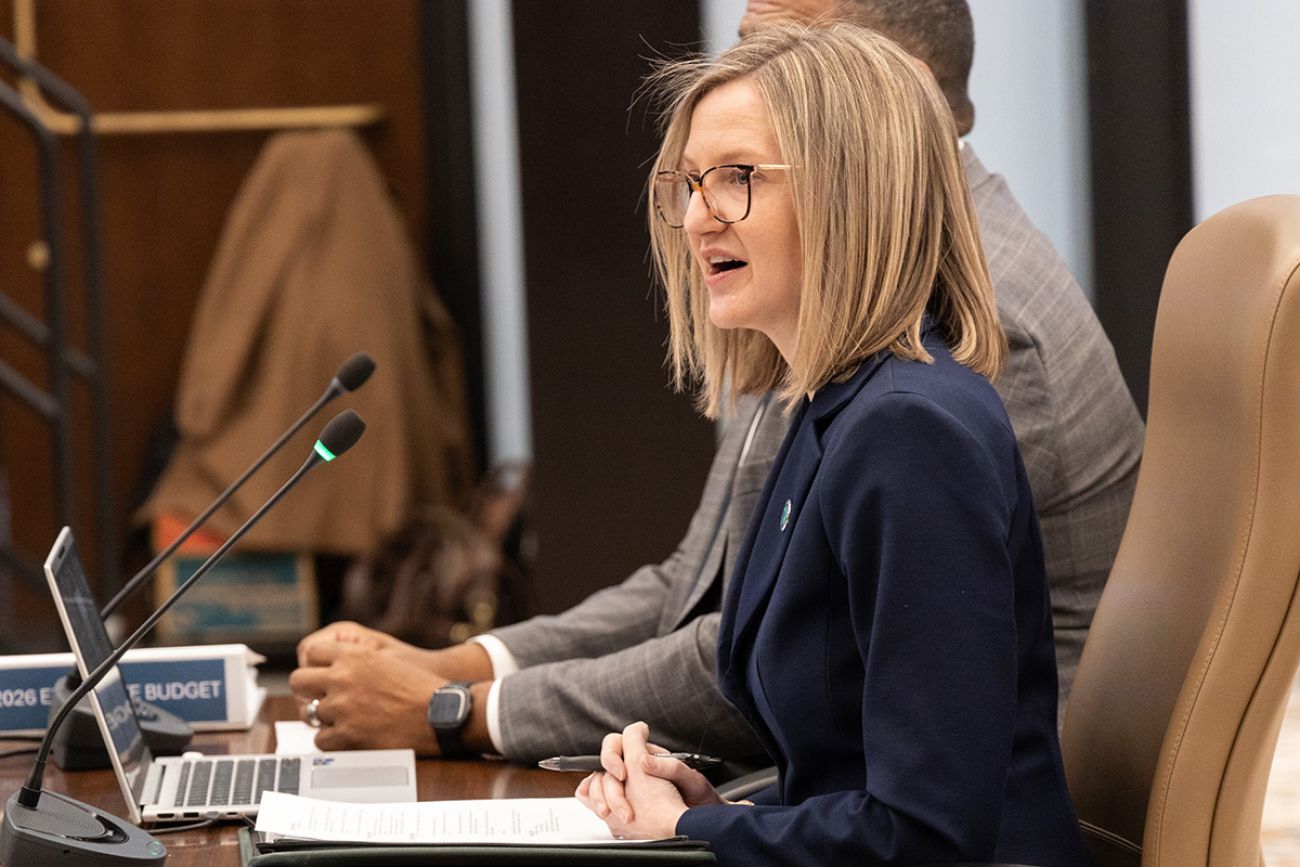 Michigan Budget Director Jen Flood sits at a table. 