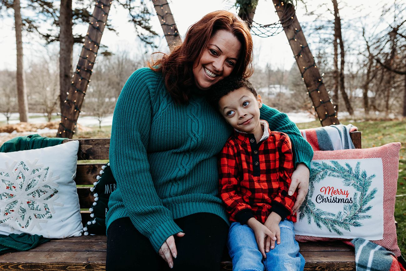 Nichole Gibbs-Risner and her son poses for a photo. They are sitting on park bench.