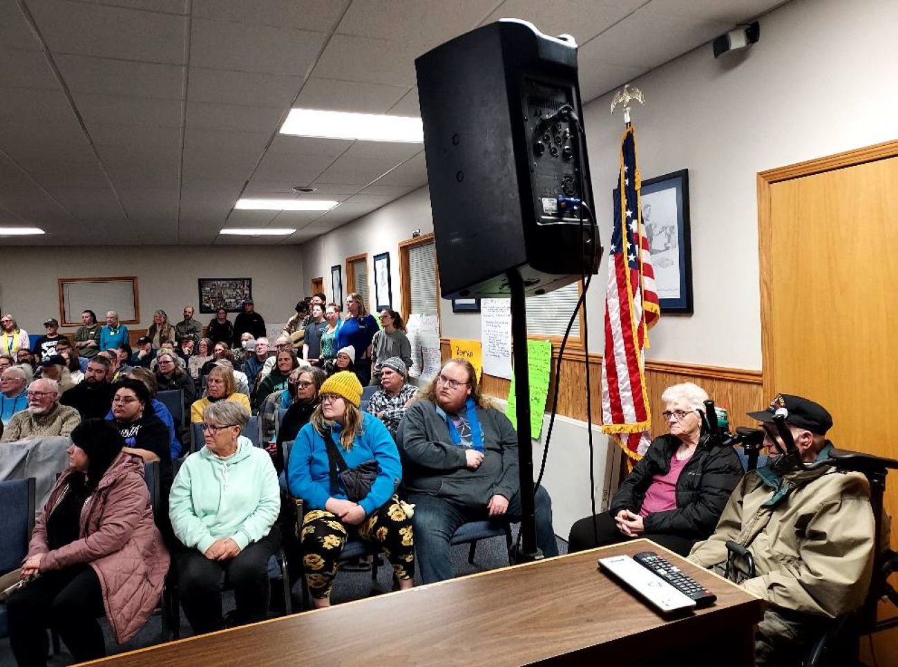 People sit in chairs in a room. 