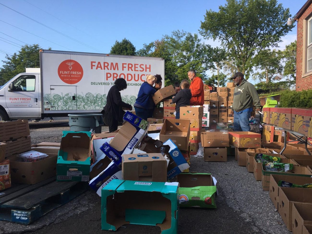 People filling up boxes to go into a van. 