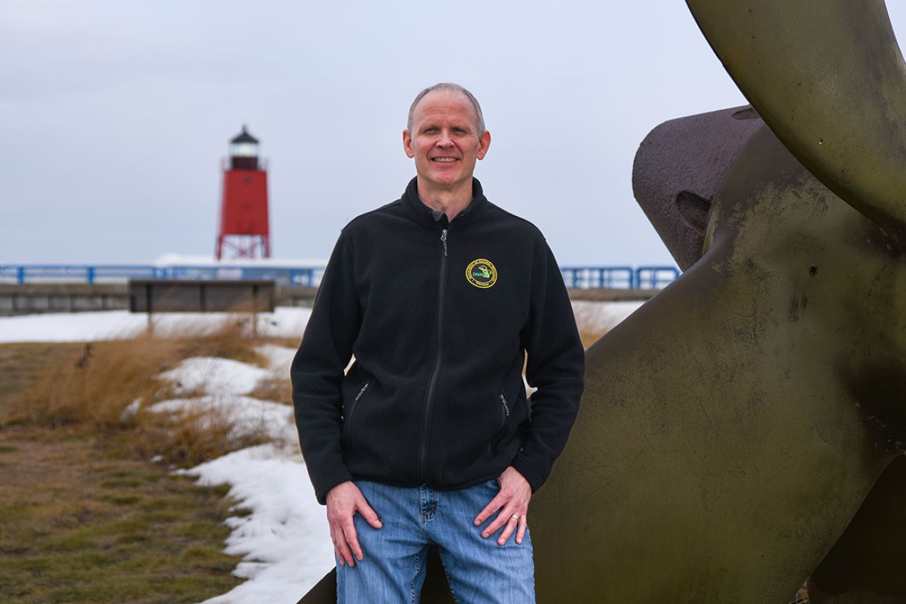 Steve Lenart poses for a picture in front of Lake Michigan.