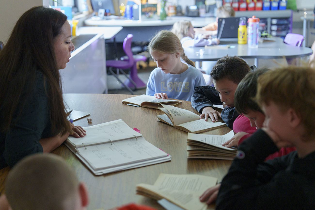 Third grade teacher Amanda Arbuckle at a table. The students reading at the table.