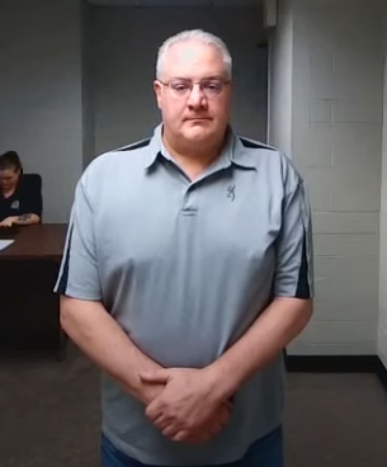 David Coker is wearing a grey polo. 