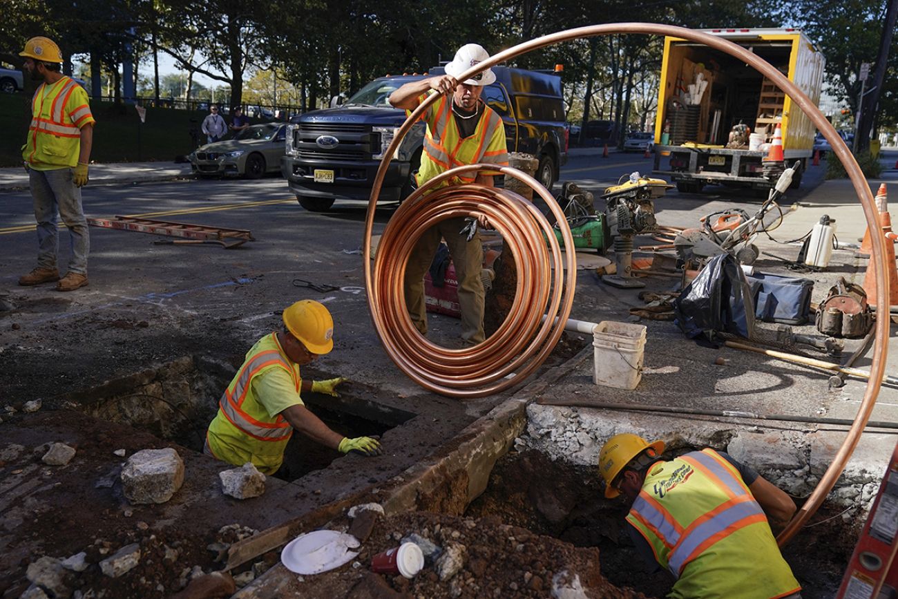 Workers are digging up a road. 