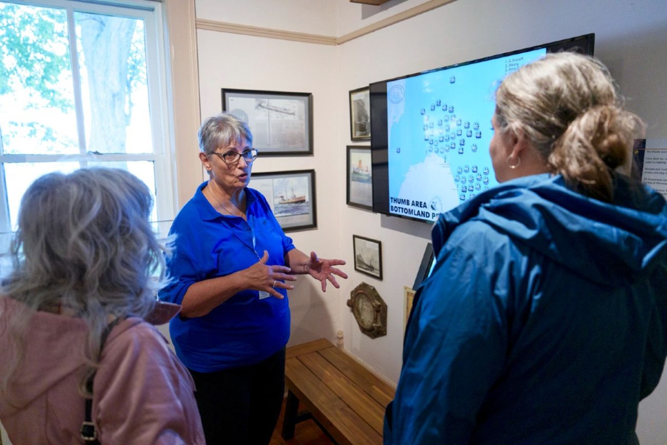 Three people stand in a room talking