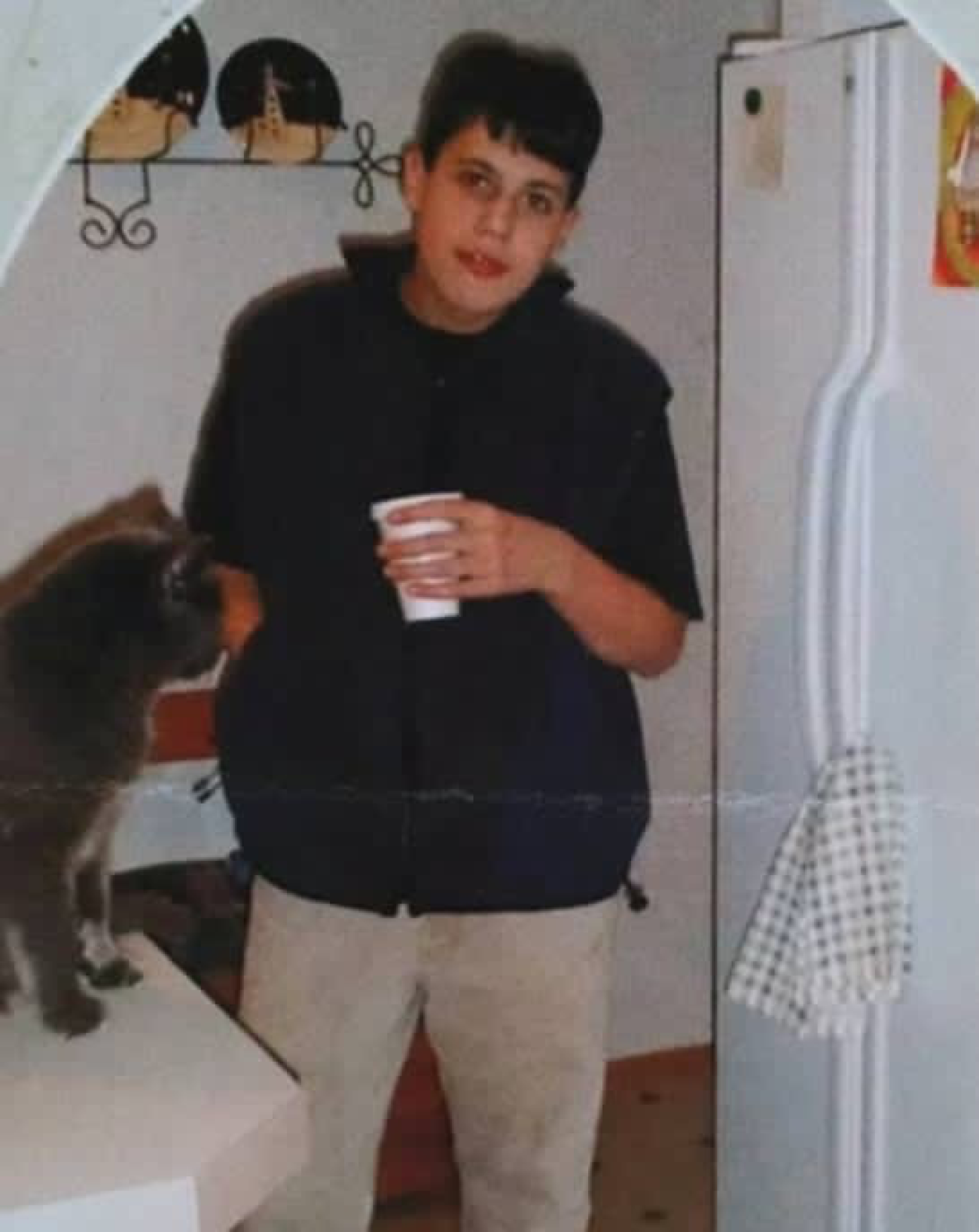 Bradford Gille poses next to a gray cat. 