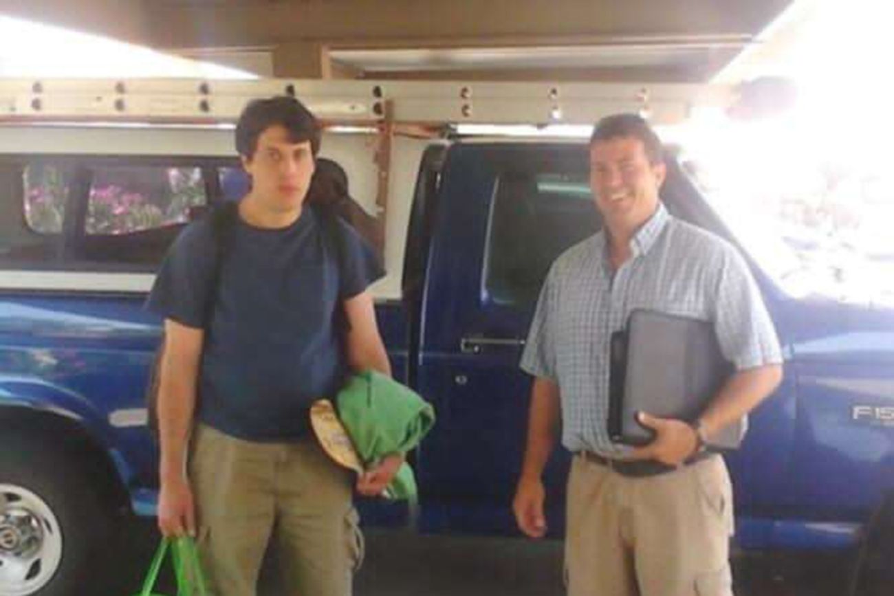 Bradford Gille and Shane Gille stand in front of a truck.