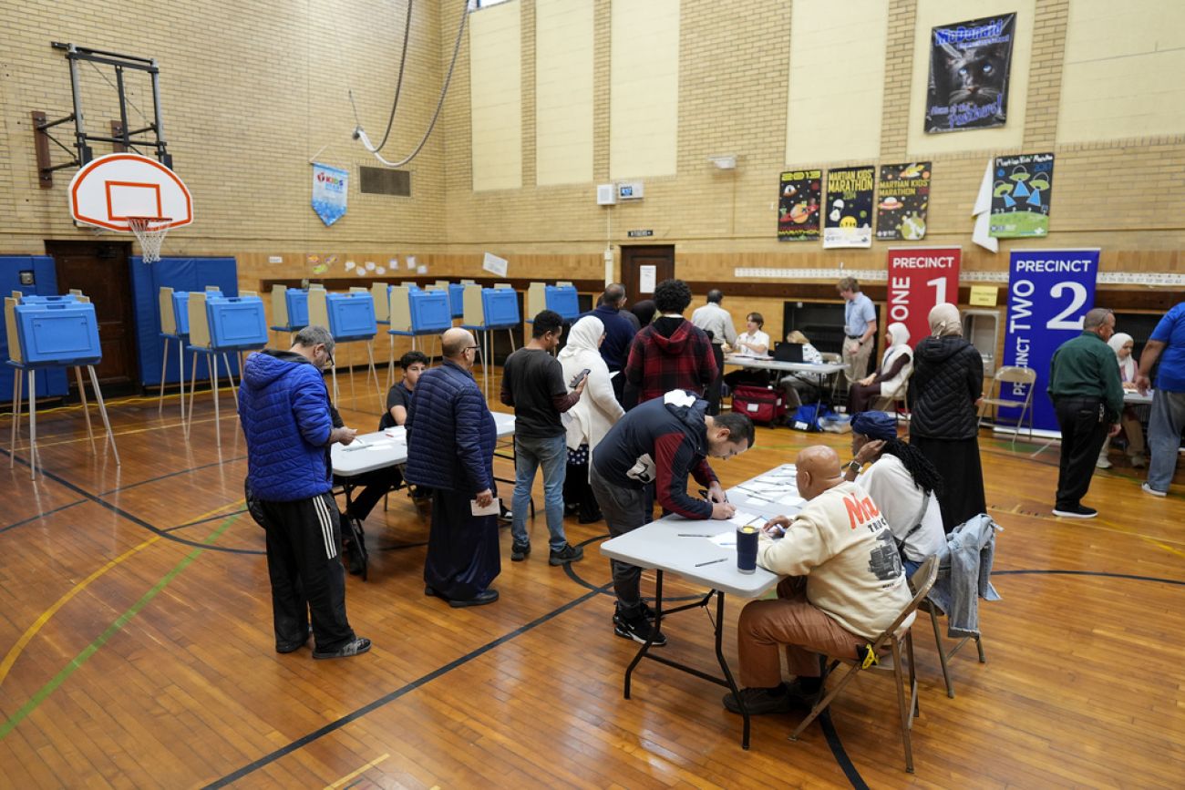 People voting in a school gym.