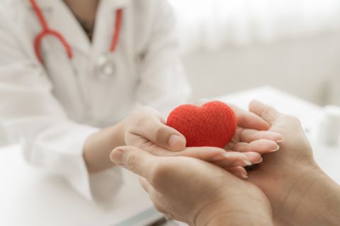 doctor and patient hands holding red heart