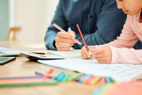 dad and daughter doing school work on table