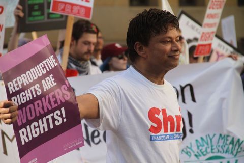 U.S. Rep. Shri Thanedar holding up a sign in a crowd