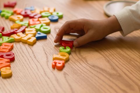 Hands lay out letters alphabet