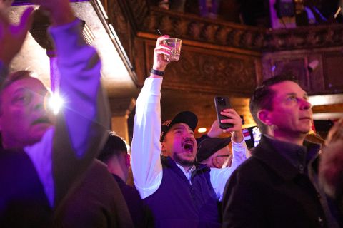 An attendee punches the air in a crowd of people