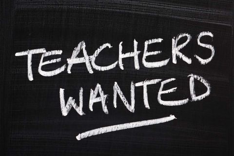 Teachers Wanted is written on a black chalkboard