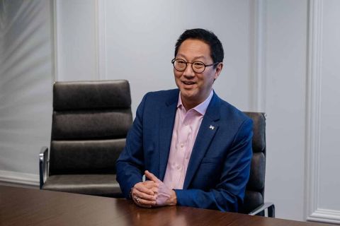 Santa Ono sits at a table. 
